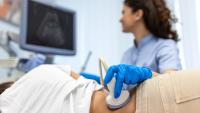 Doctor conducts ultrasound examination of patientv kidneys. Internal organs ultrasound concept. female's lower back diagnosis carried out with the use of an ultrasound.
